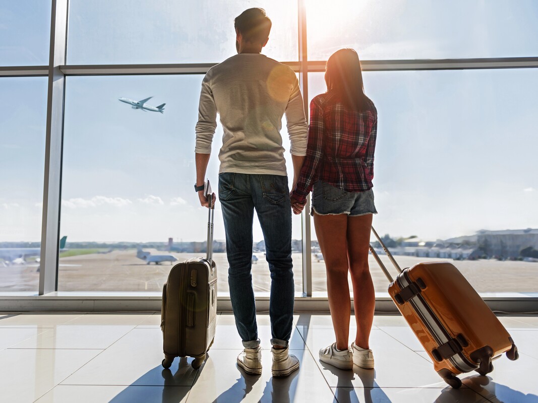 Traveling couple with carry-on luggage