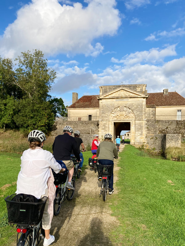 Cyclists in Vauban architecture on the Médoc Bicycle Tour